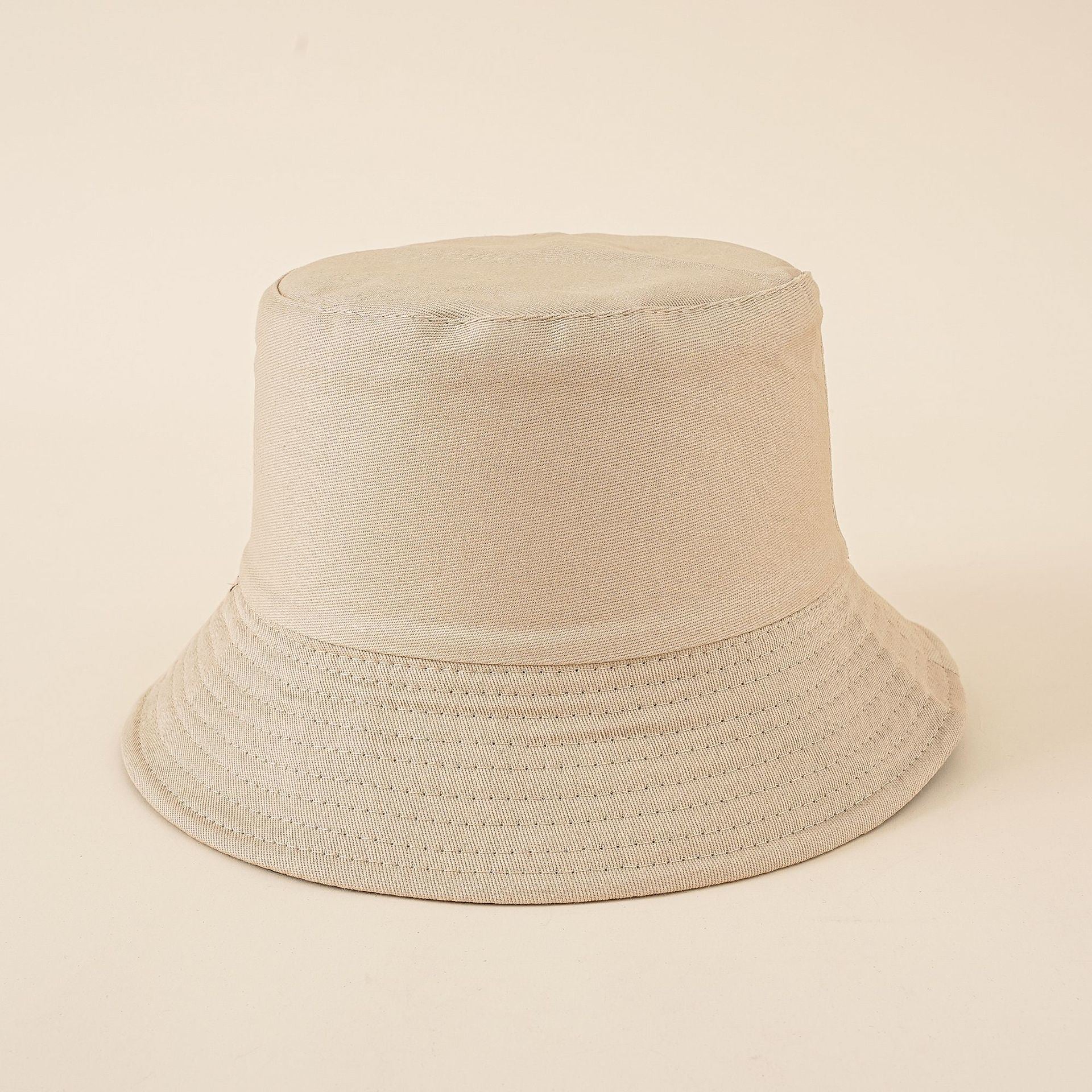 Cream solid bucket hat with perforated stitched brim and flat crown