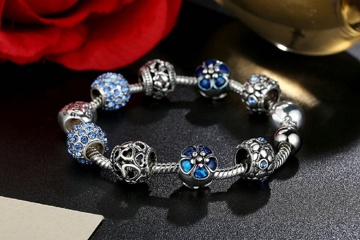 Blue flower charm bracelet with silver-tone beads and heart Love centerpiece.