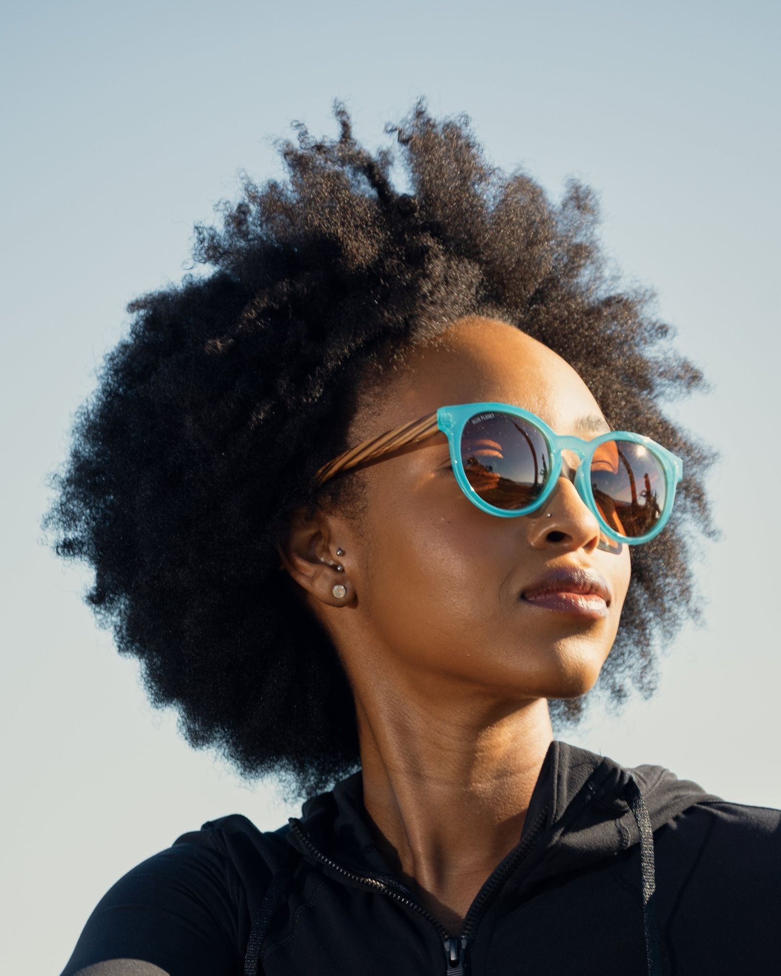 Turquoise round polarized sunglasses with brown lenses on a person