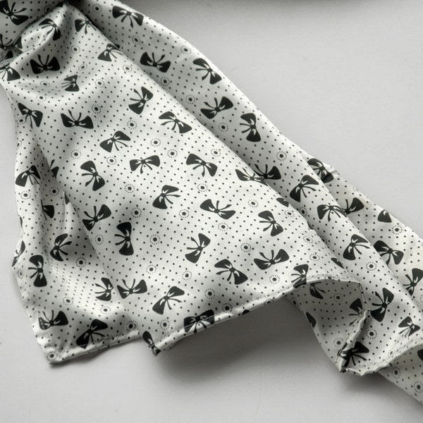 Silk scarf detail, white fabric with black butterfly and dot motif