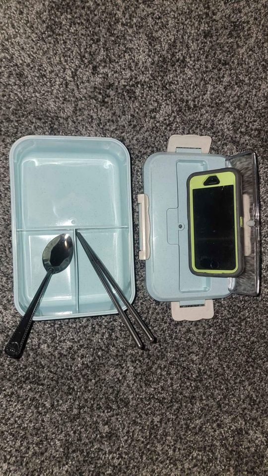 Blue bento box open with phone-sized holder and utensil set