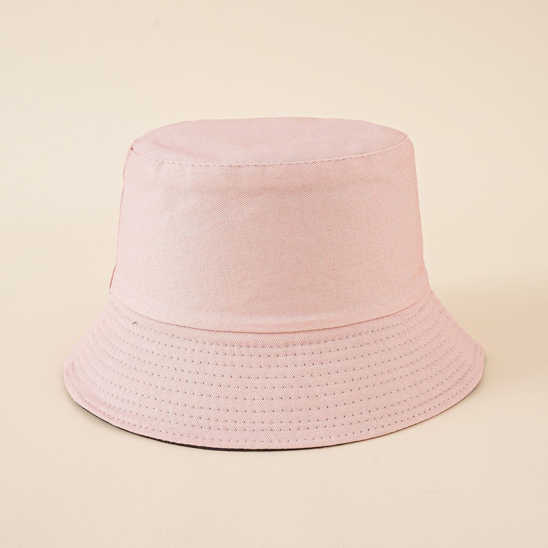 Pink solid bucket hat with flat crown and perforated stitched brim