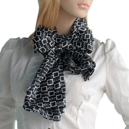 Silky black scarf with white chain-and-square pattern, ruffled bow at collar