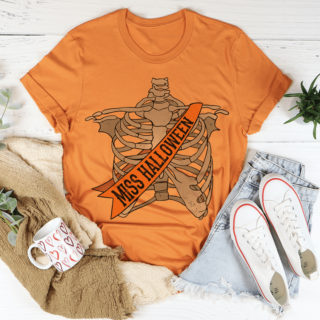 Burnt-orange crew-neck T-shirt featuring skeleton wings design with 'Miss Halloween' banner.
