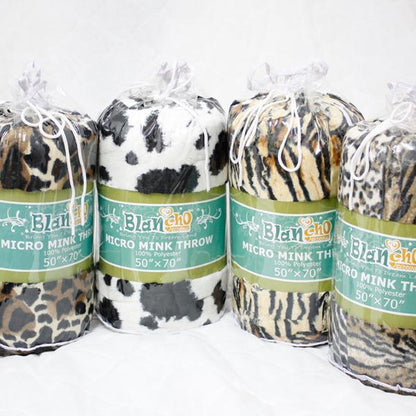 Animal print micro mink throw blankets in rolls, with green label bands