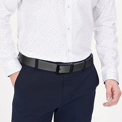Nylon ratchet belt with dark textured webbing, worn at waist with navy trousers