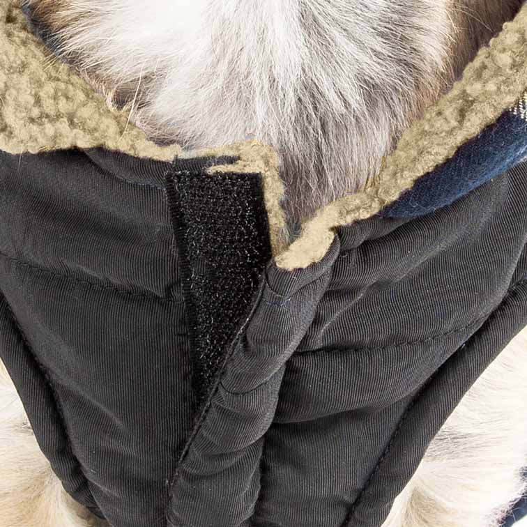 Close-up of insulated dog coat: black quilted fabric, sherpa trim, and hook-and-loop fastener