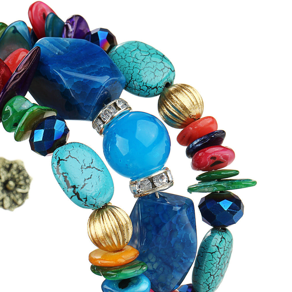 Close-up boho charm bracelet with blue, red, green beads and textured shell beads