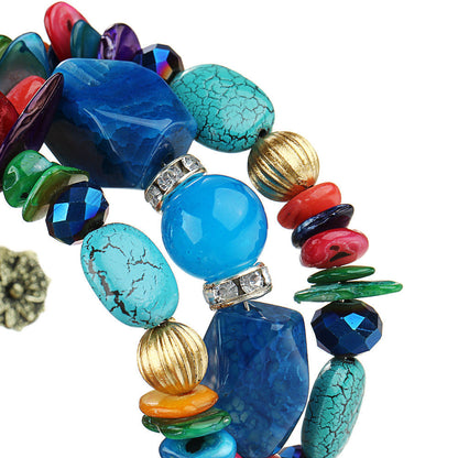 Close-up boho charm bracelet with blue, red, green beads and textured shell beads