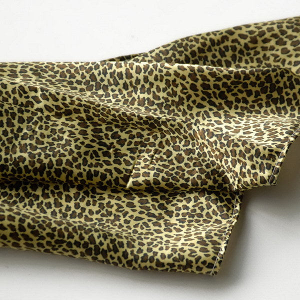 Leopard print silk scarf fabric close-up with olive and tan pattern folds