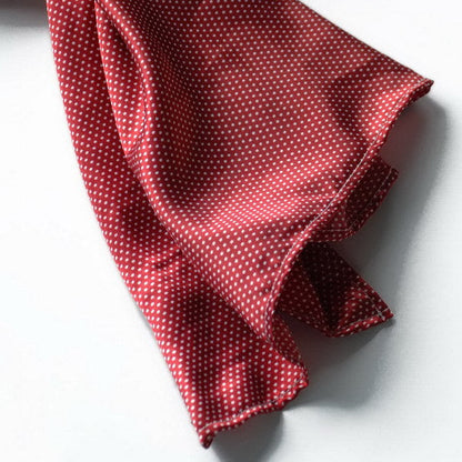 Red silk scarf with small white polka dots, draped and folded