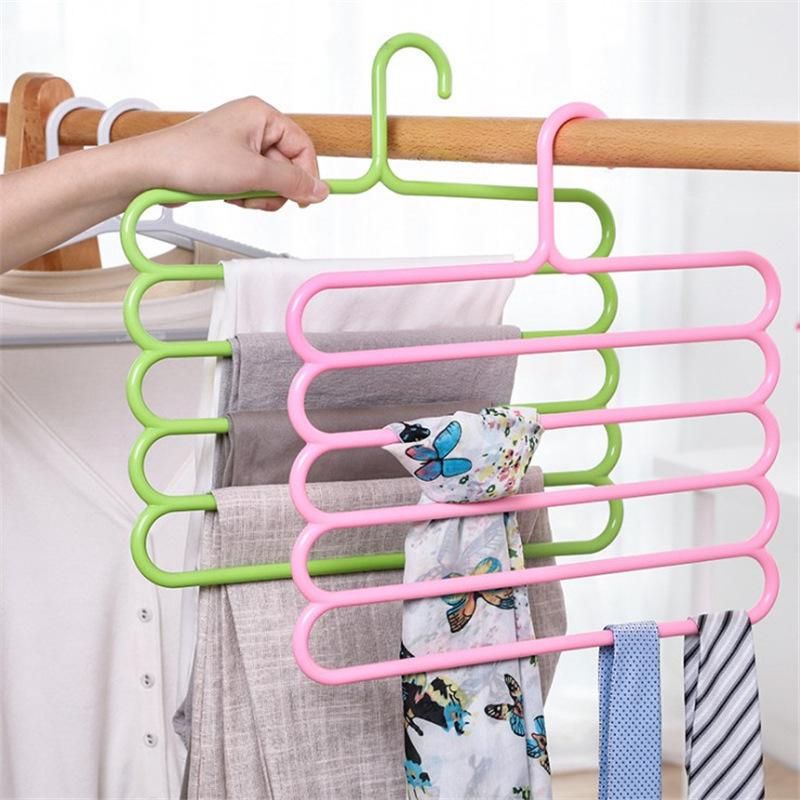 Multipurpose plastic cabinet hanger with 5 bars in green and pink, holding folded cloths