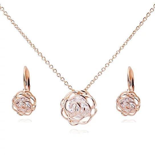 Rose gold rose pendant necklace with matching rose earrings and blue-clear center