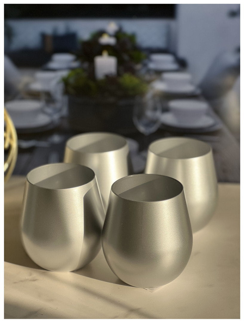 Four metallic gold plastic wine glasses, stemless goblet on table