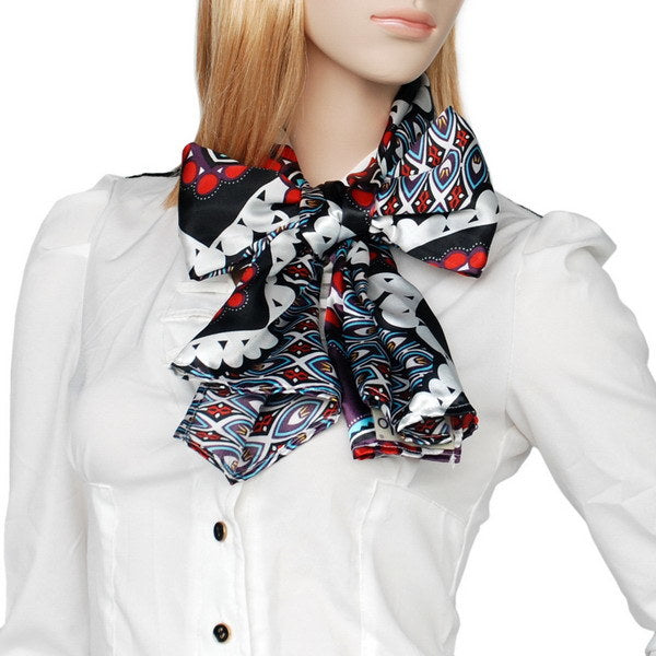 Large bow-tied scarf on model, black and white with red and purple geometric patterns