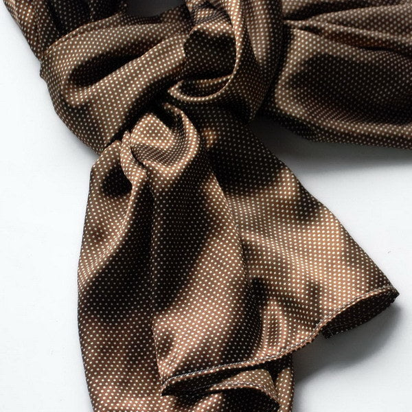 Brown polka-dot silk scarf folded with long tails