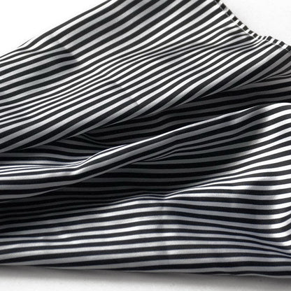 Close-up of black and white striped fabric with flowing folds