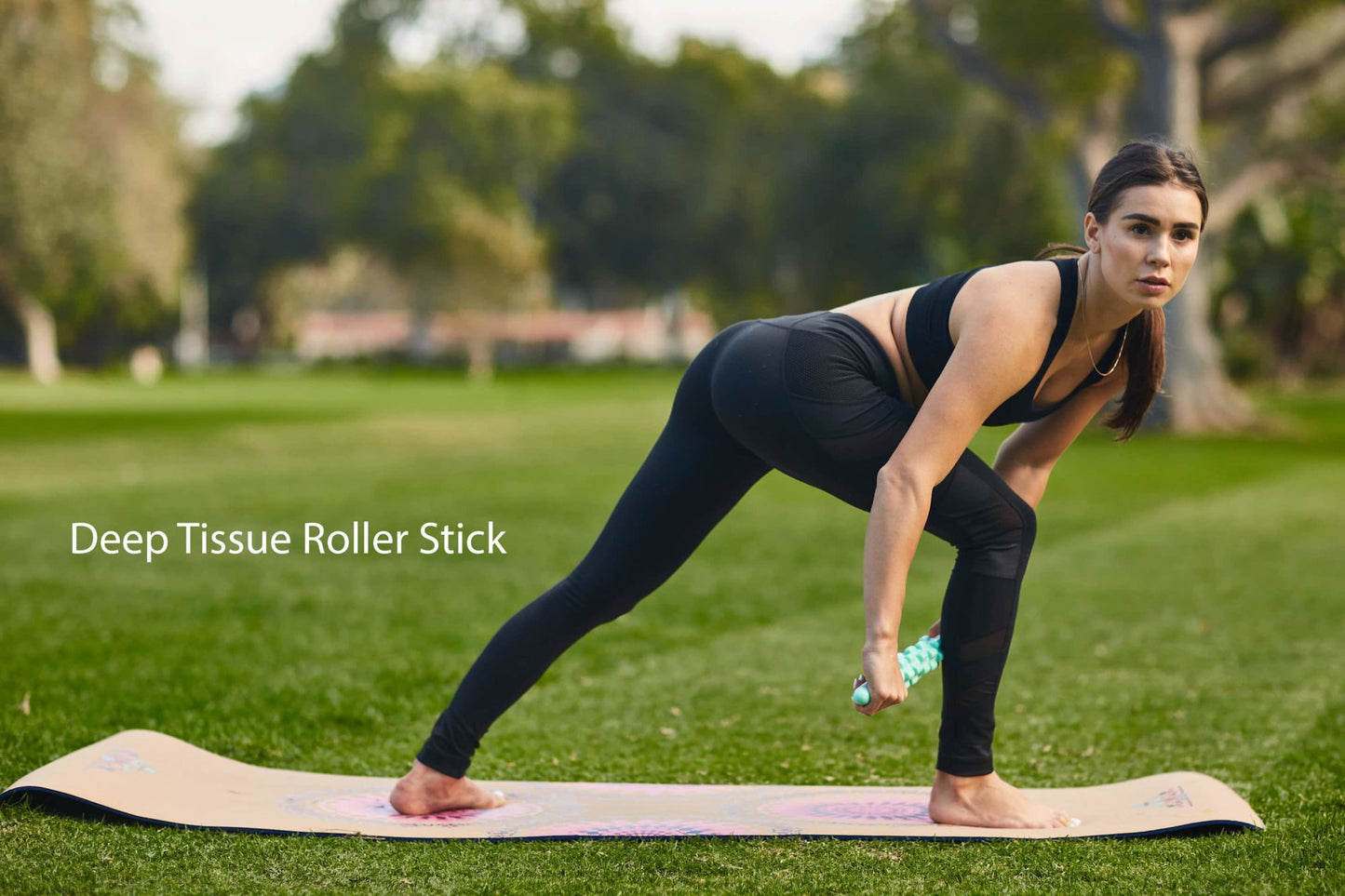 Deep tissue roller stick used on a yoga mat during floor stretch