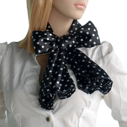 Black silk scarf with white polka dots, tied in a bow at the neck