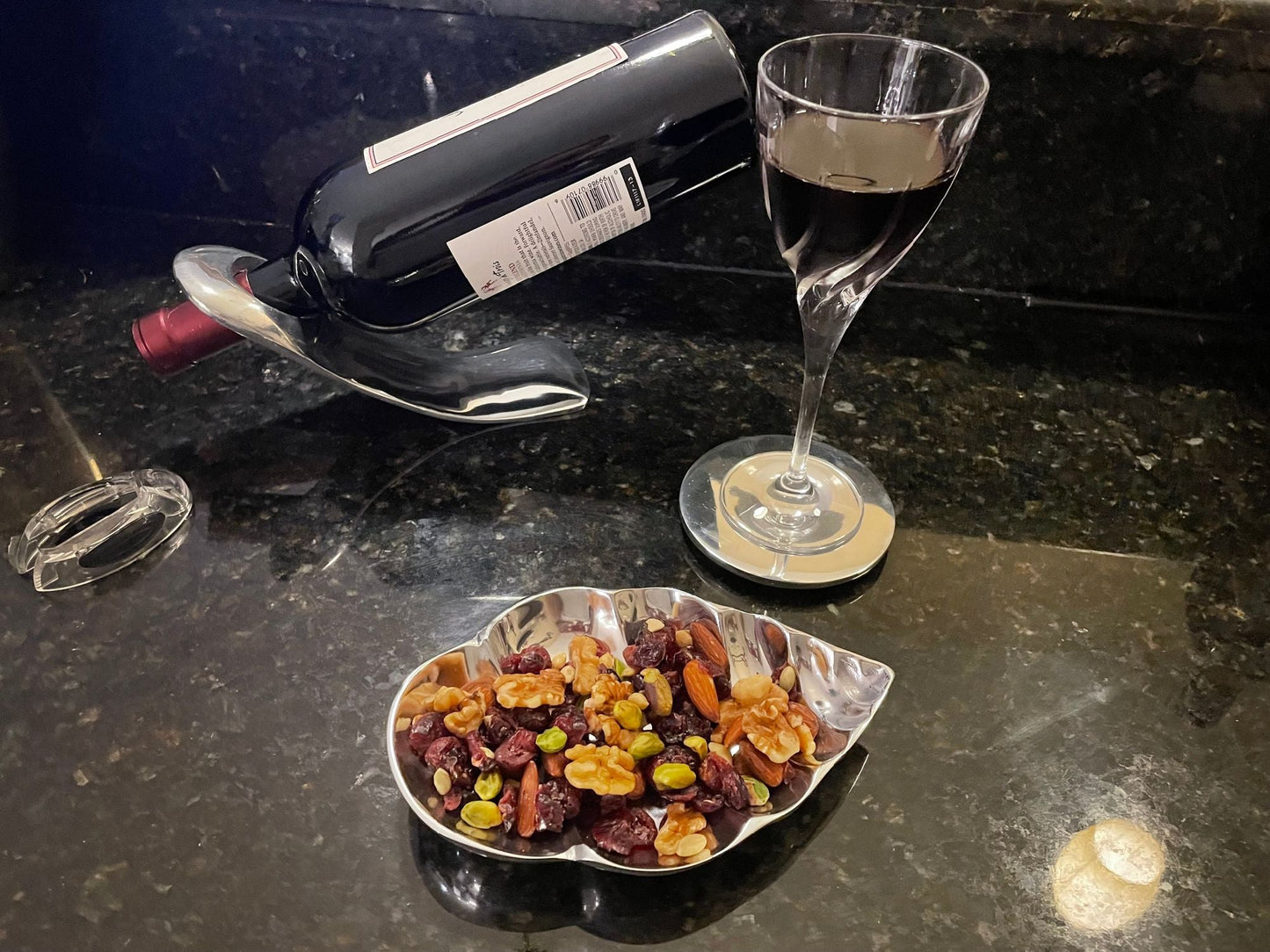 Round metal coaster with a stemmed glass on a dark tabletop