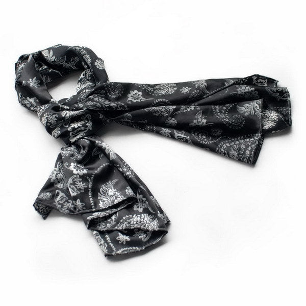 Black silk scarf with white floral and paisley pattern, loosely folded