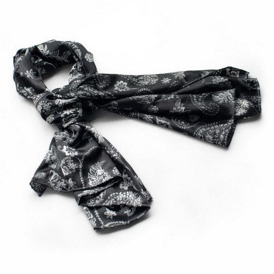 Black silk scarf with white floral and paisley pattern, loosely folded
