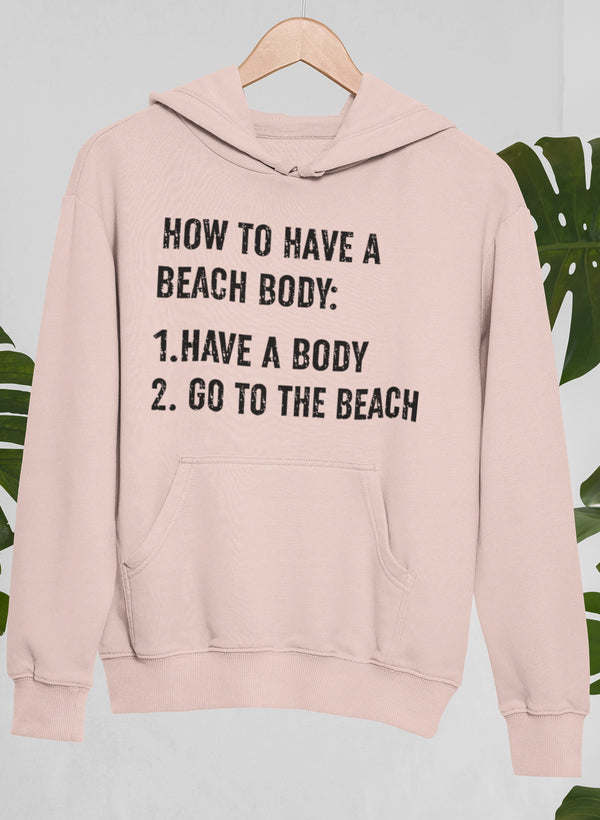 Blush pullover hoodie with hood, front pocket, and beach-body text graphic