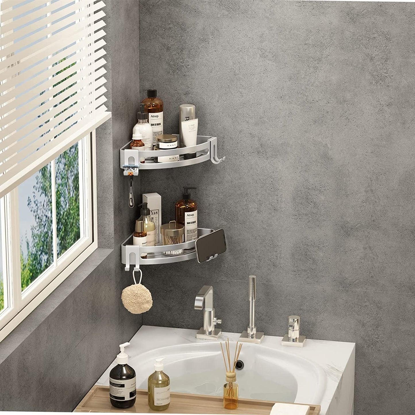Silver two-tier corner shower shelf caddy holding bottles, jars, and soap