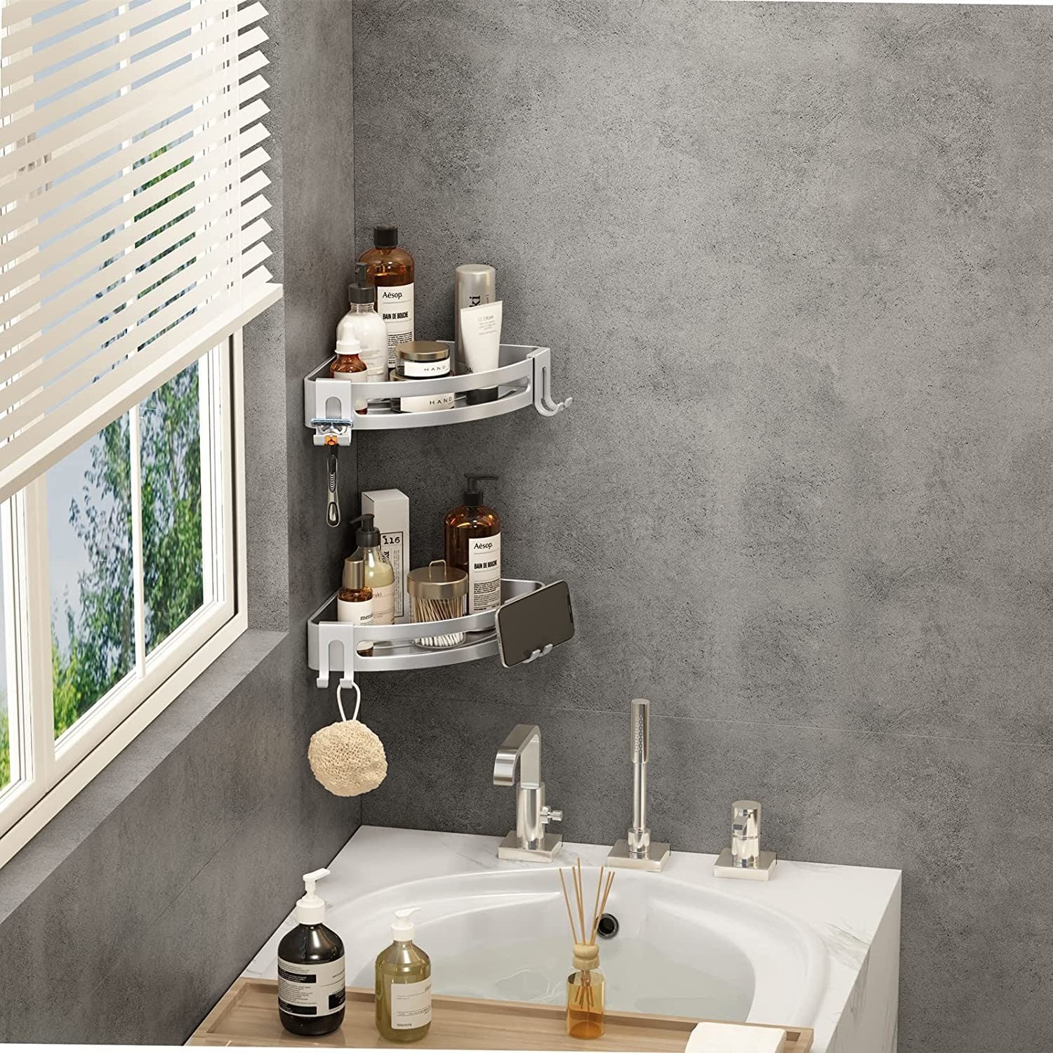 Silver two-tier corner shower shelf caddy holding bottles, jars, and soap