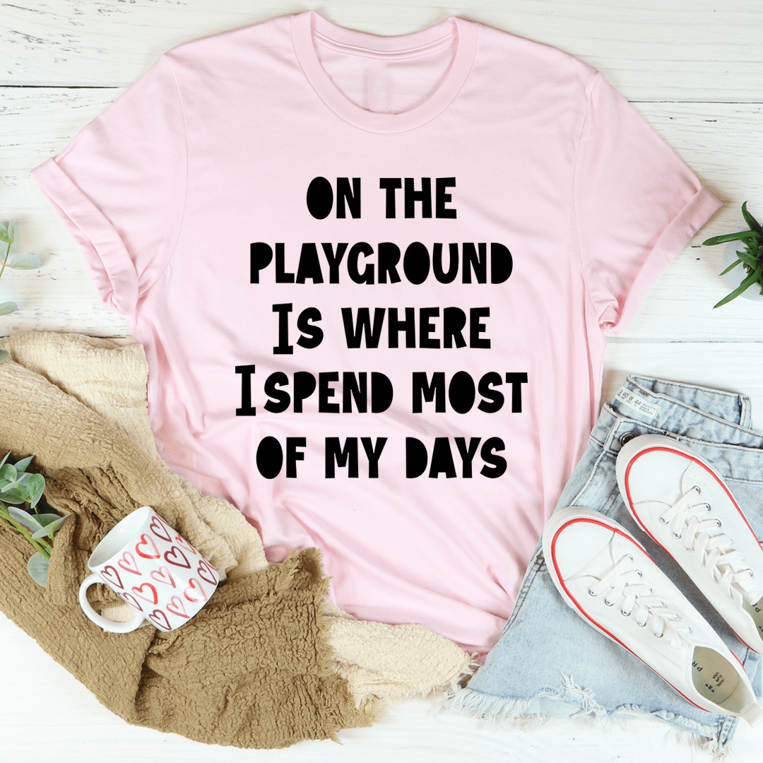 Pink short-sleeve T-shirt with bold "ON THE PLAYGROUND IS WHERE I SPEND MOST" text