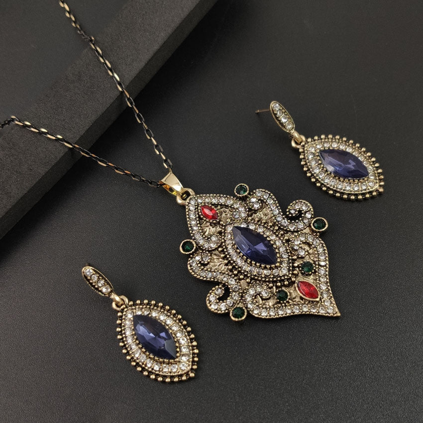 Blue oval pendant necklace with matching blue drop earrings and red stone details