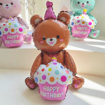 Bear-shaped foil balloon hugging cake, brown bear holding white polka-dot cake, "Happy Birthday"