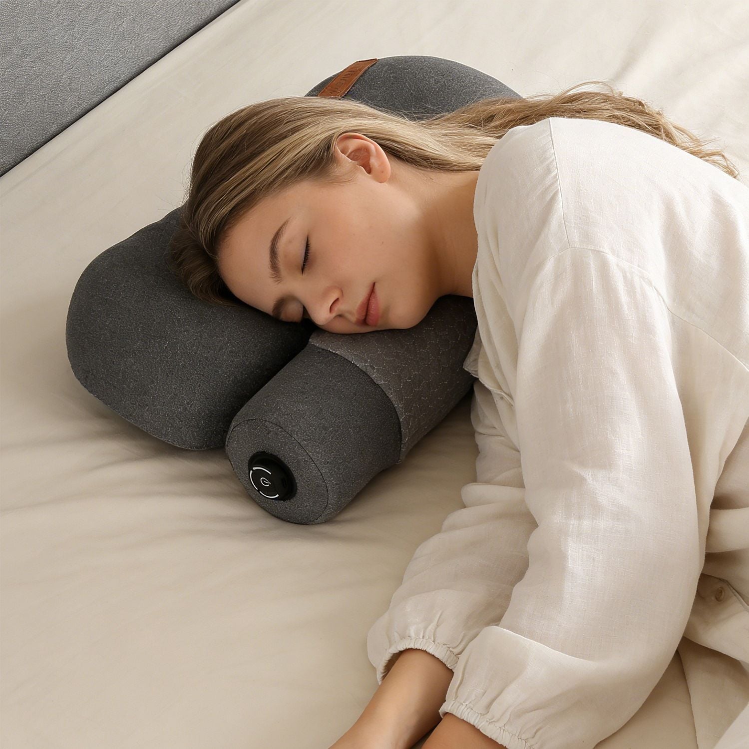 Dark grey heated cervical neck pillow supporting a sleeping person’s head