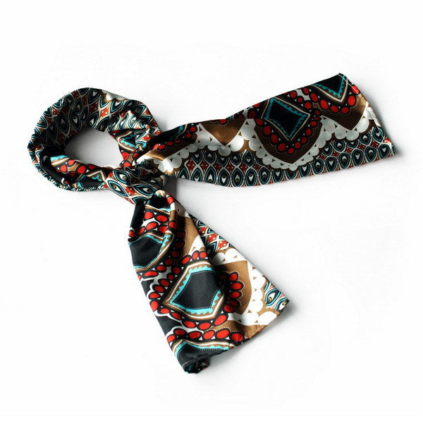 Silky scarf wrap with black base, red, teal, and white geometric patterns, laid flat.