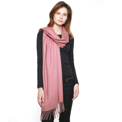 Dusty rose pink pashmina shawl with fringe trim, draped over shoulder