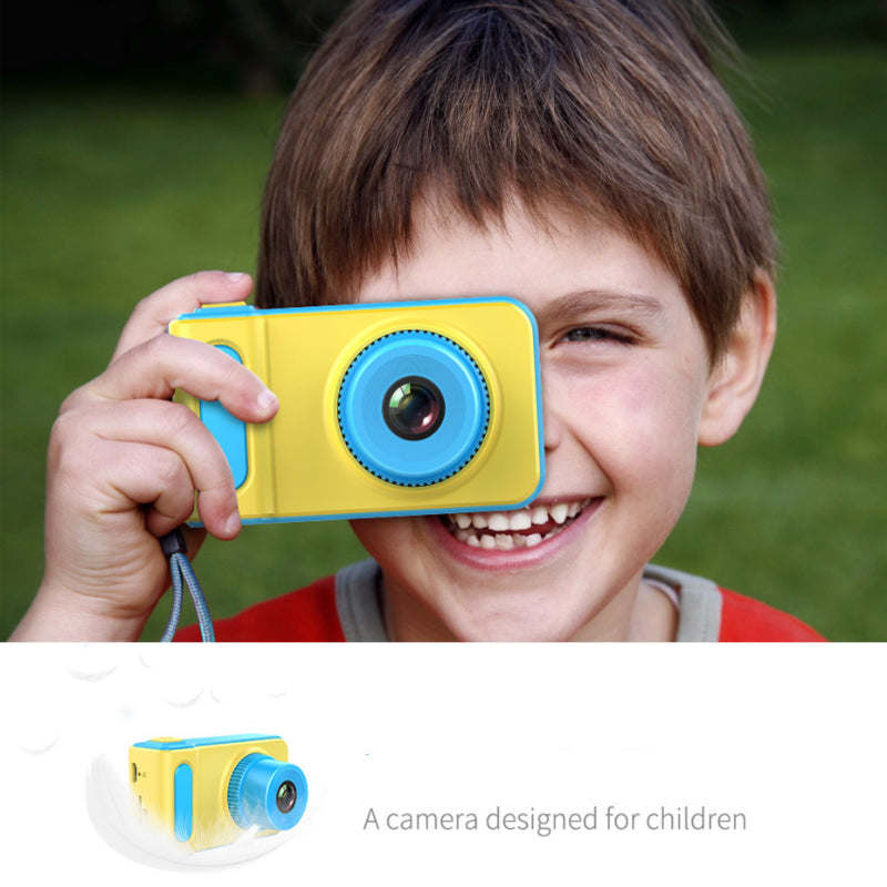 Kids mini digital video camera, yellow case with blue lens, child holding it up