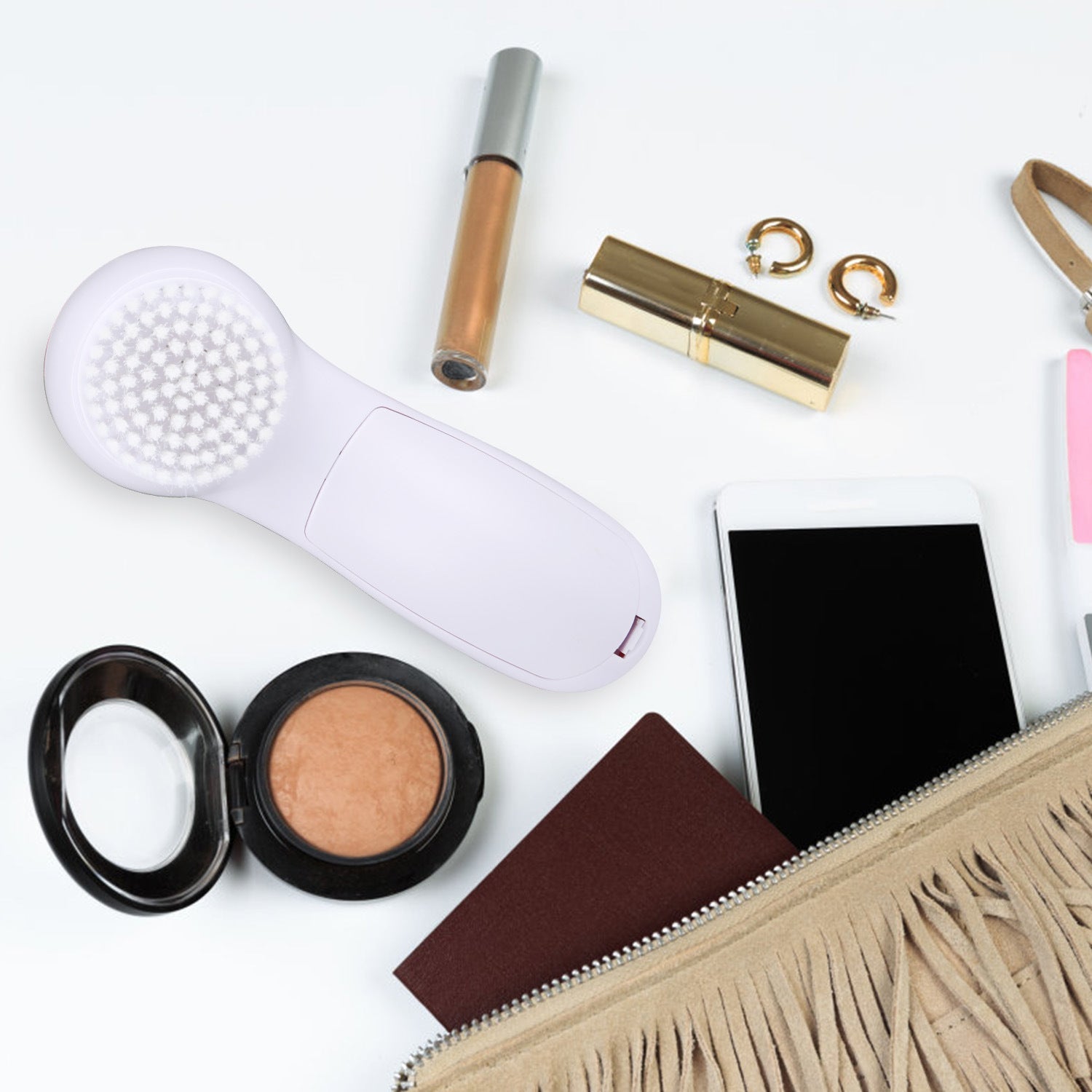 Pink-and-white electric face cleansing brush with round bristle head on countertop