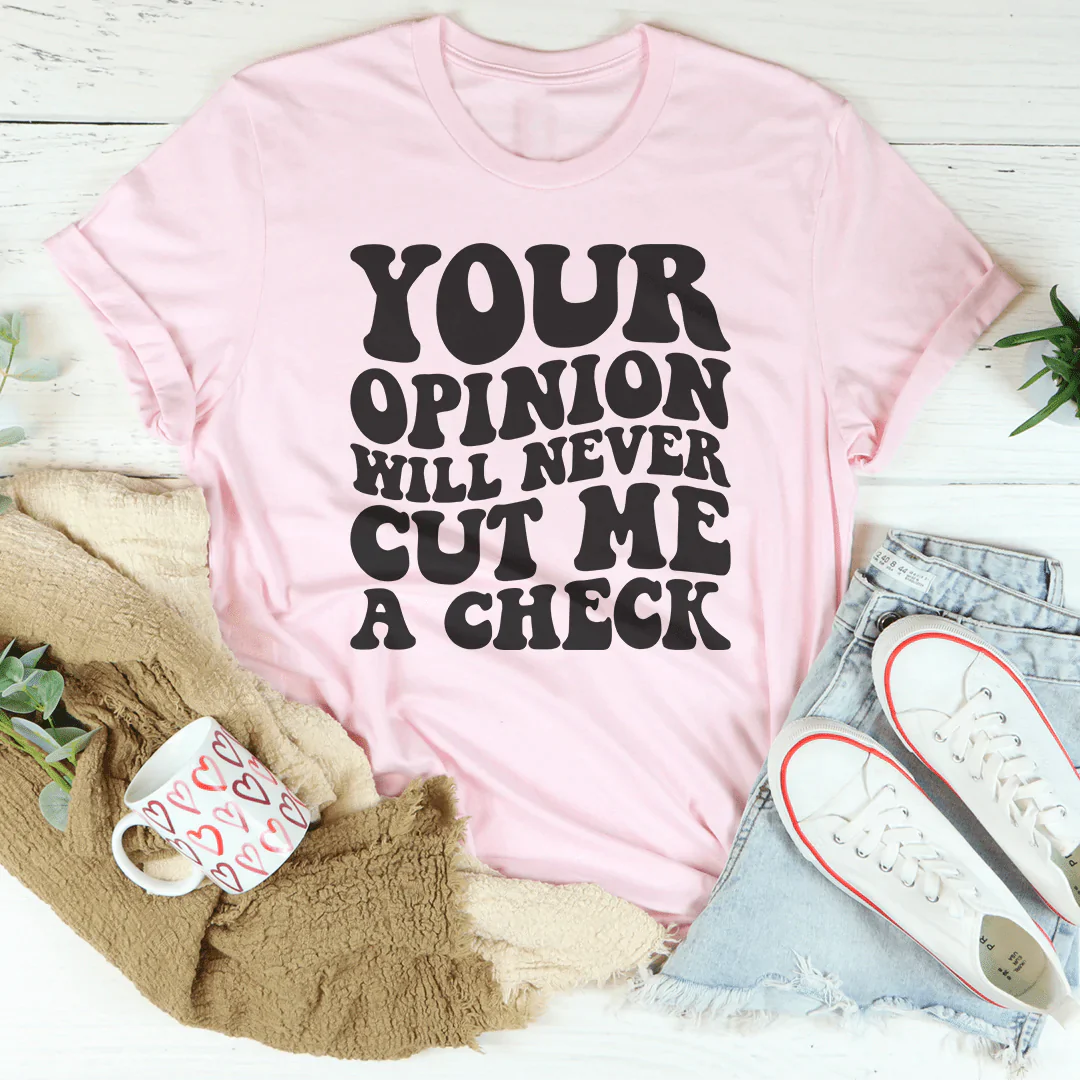 Light pink crew-neck T-shirt with bold black text: YOUR OPINION WILL NEVER CUT ME