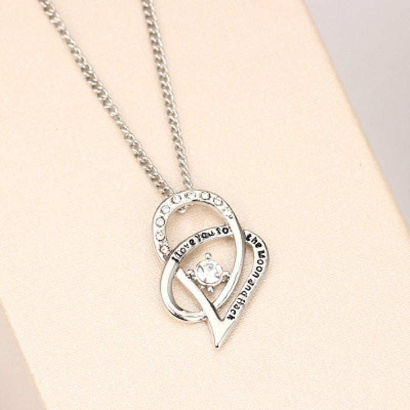 Sterling silver heart pendant necklace with cubic zirconia and engraved words around the bezel