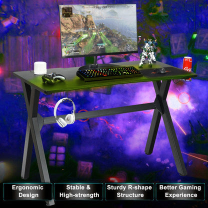 Black gaming desk with mouse pad, keyboard, and cup holder with headset