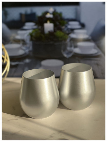 Two metallic gold plastic wine glasses, stemless goblet on table