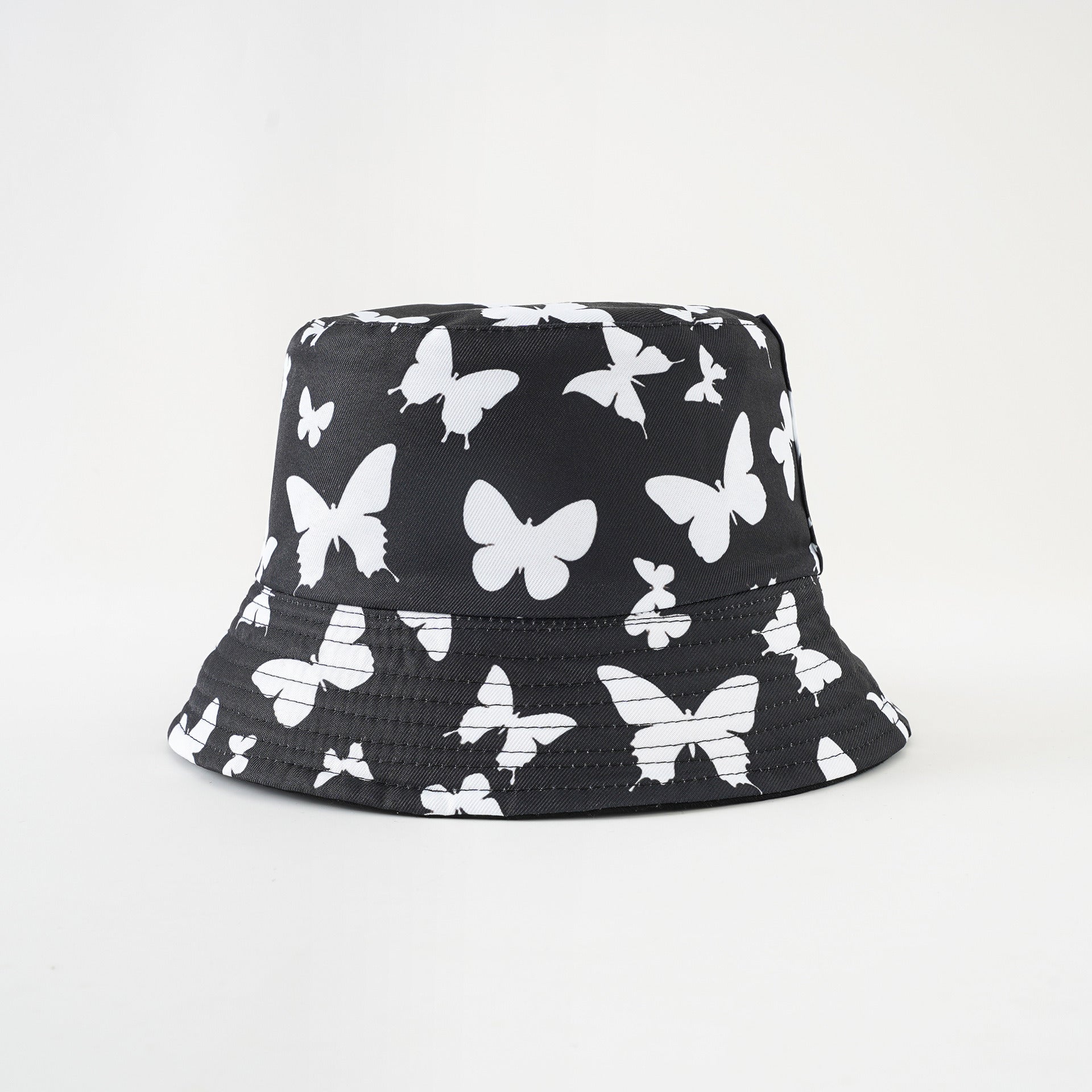 Black bucket hat with white butterfly pattern, wide brim