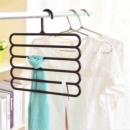 5-layer plastic hangers on a rod holding folded garments in mint and white