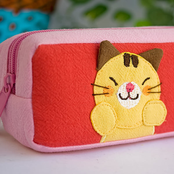 Embroidered cat applique on red-and-pink pencil pouch with pink zipper trim