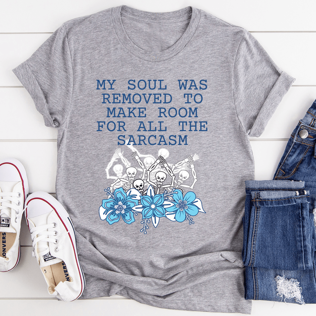 Gray graphic T-shirt with blue text and skulls-and-flowers illustration