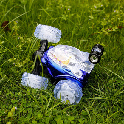 Remote control stunt car in dark blue with clear bubble wheels on grass