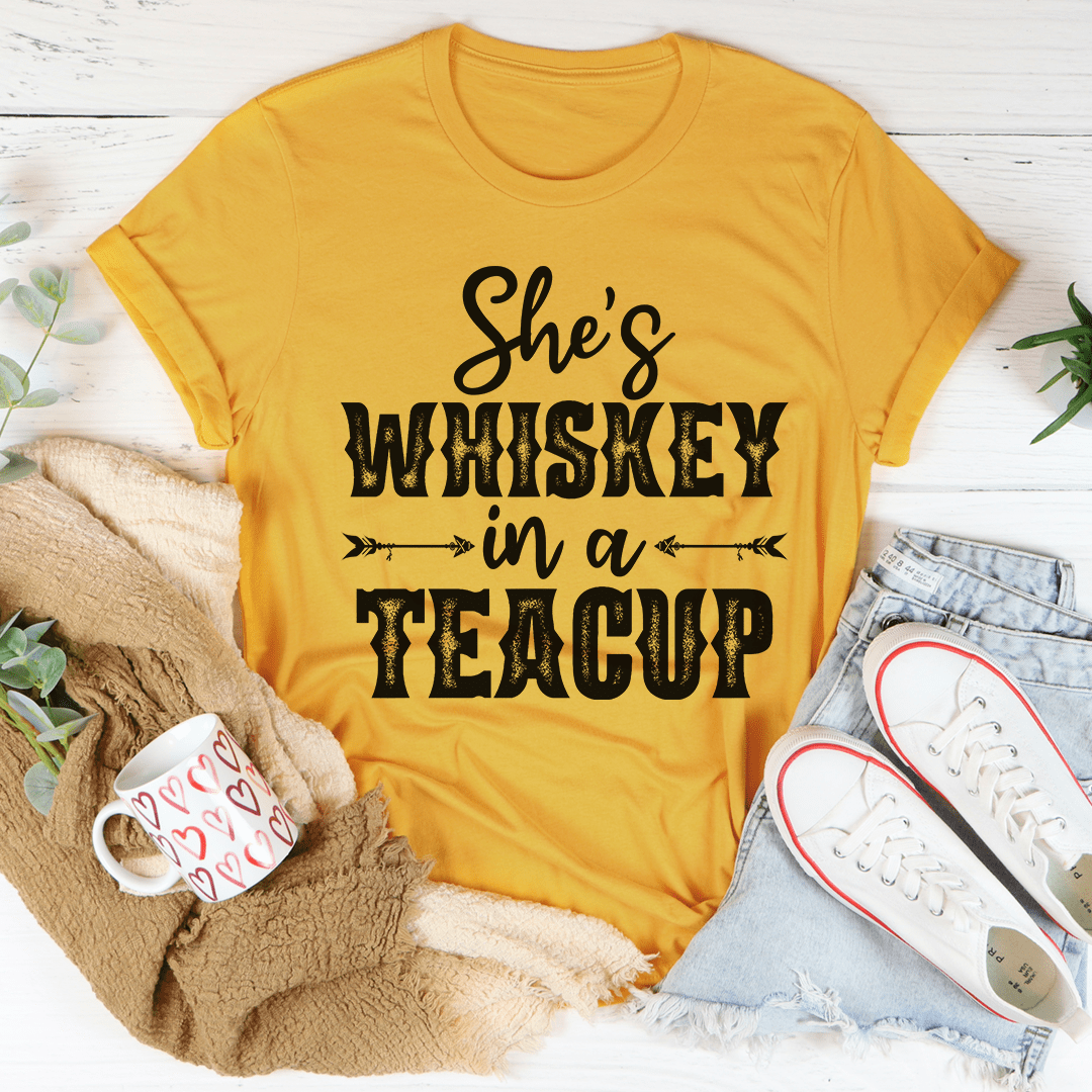 Mustard yellow T-shirt with “She’s Whiskey in a Teacup” graphic on the front
