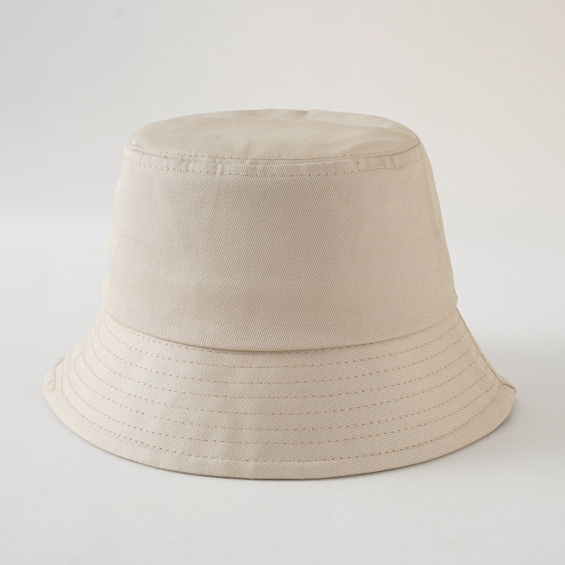 Beige fabric fisherman hat with wide brim and stitched decorative rows