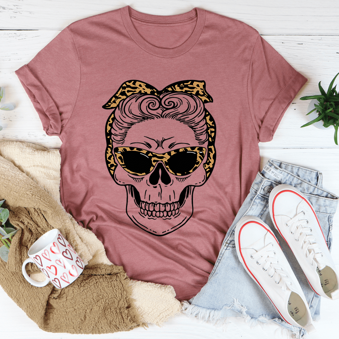 Pink crew-neck T-shirt with cartoon skull in leopard bandana and sunglasses graphic.