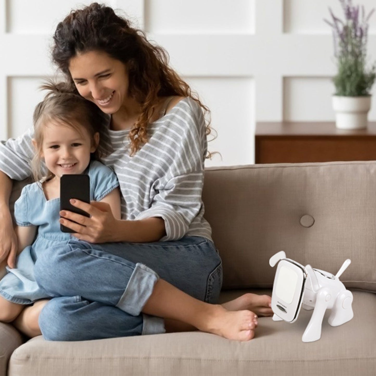 White puppy-shaped wireless speaker on sofa near a child holding a smartphone
